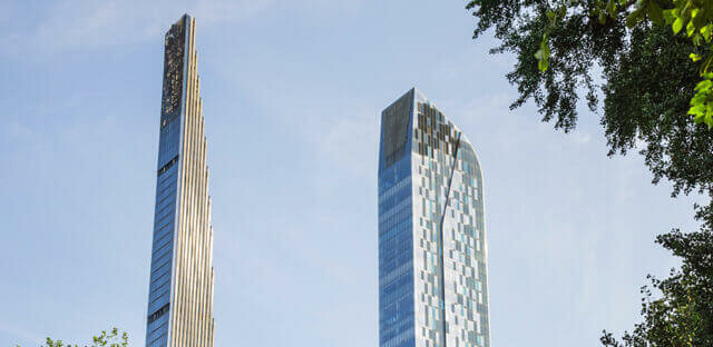 Two tall buildings peaking through trees